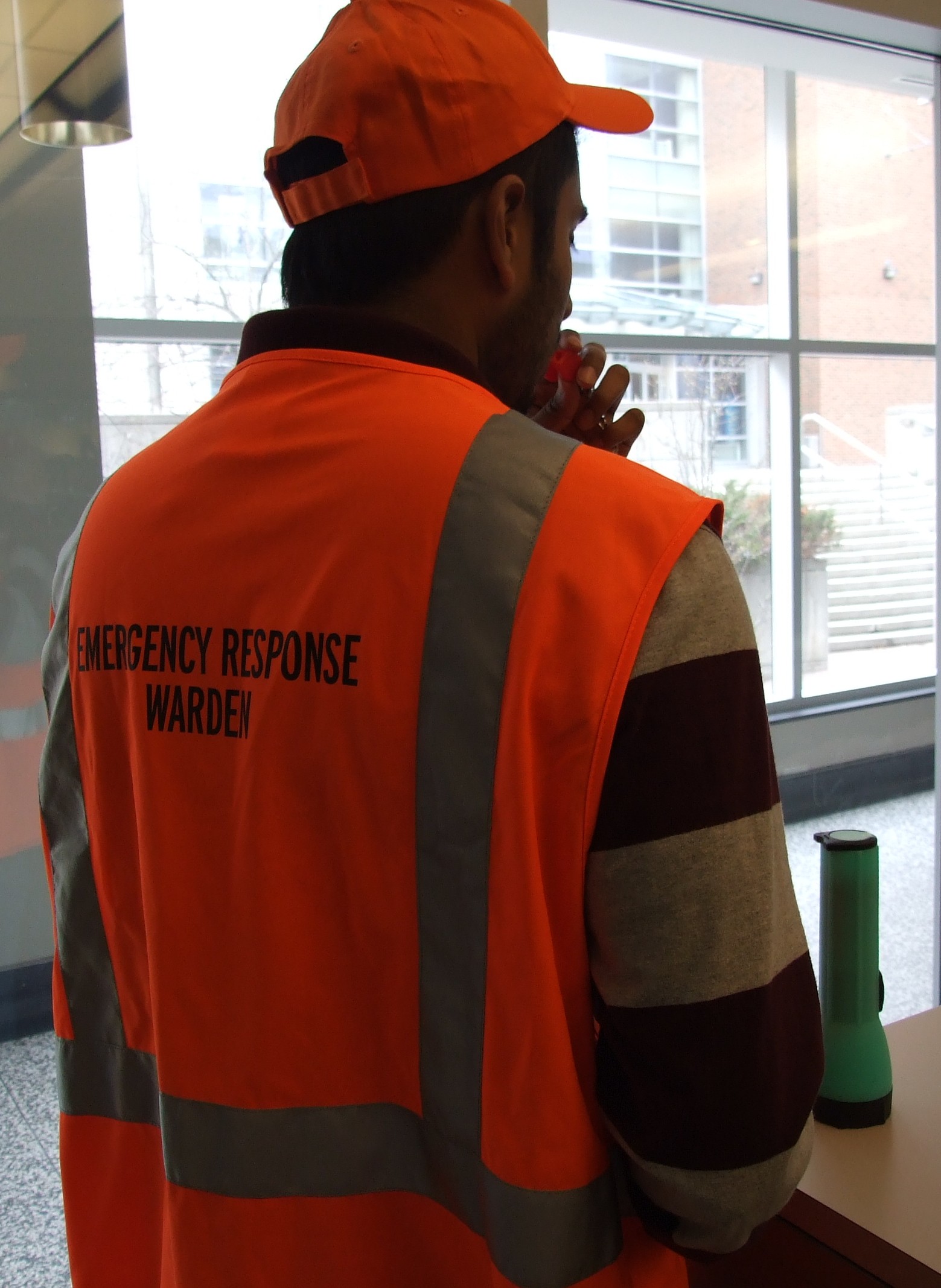 A Person with an Orange Vest Displaying Emergency Response Warden blowing a whistle